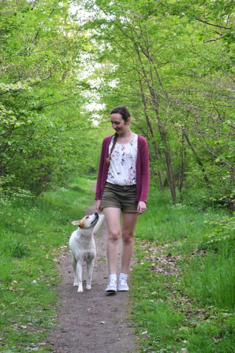 Joana und Ruby gehen aufmerksam miteinander durch einen grünen Wald